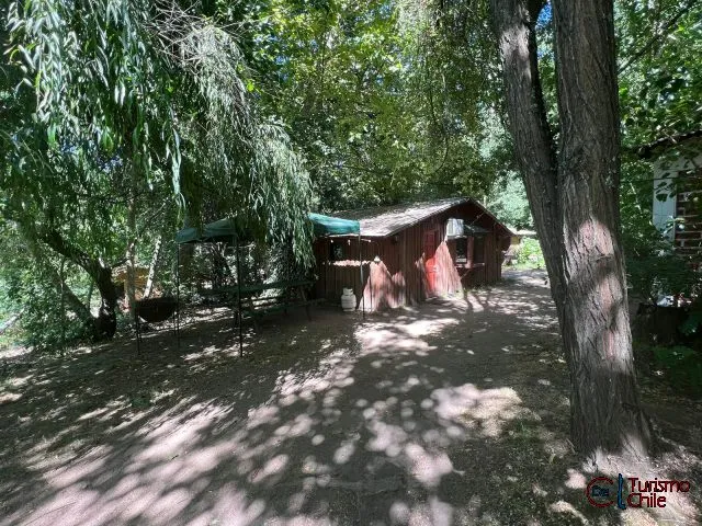 Sitios de camping con carpas y mesas bajo los árboles en Las Vertientes