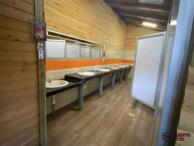 Sitio 15 de Camping Las Vertientes con mesa de picnic y techo de madera